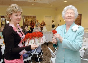 Mary McCall (right) accepts a rose from Amber Thompson, Baylor Round Table’s 2004-05 president-elect, at the group’s 100th birthday party.