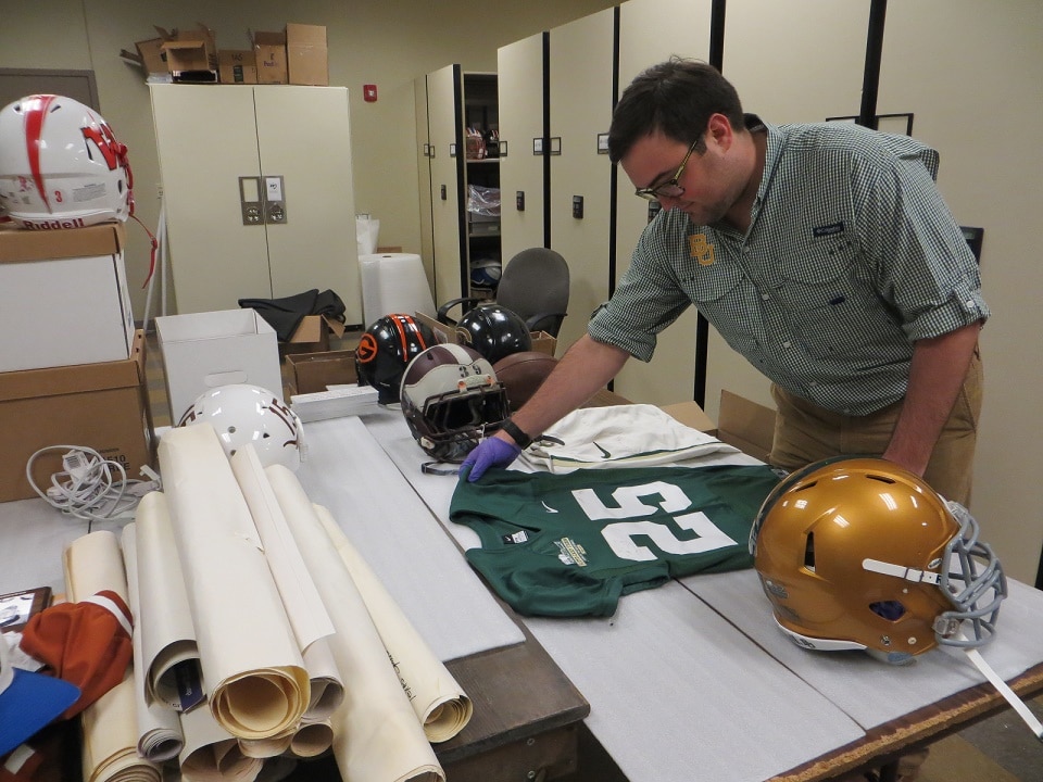 Ryan Sprayberry '12 looks over some potential exhibit objects at the Texas Sports Hall of Fame